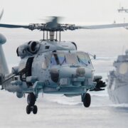 Military helicopter flying above water